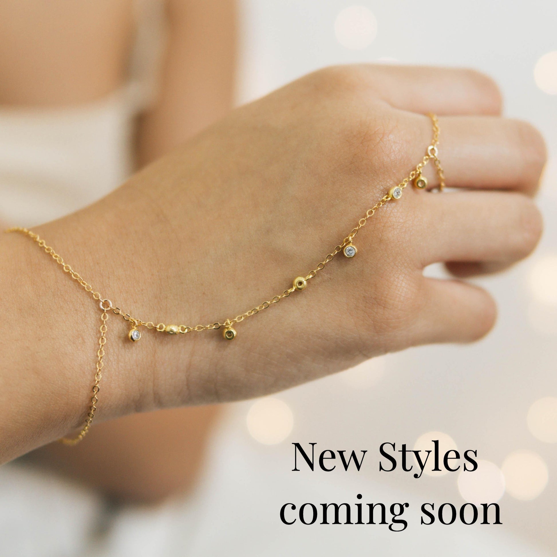 a woman's hand with a gold chain bracelet