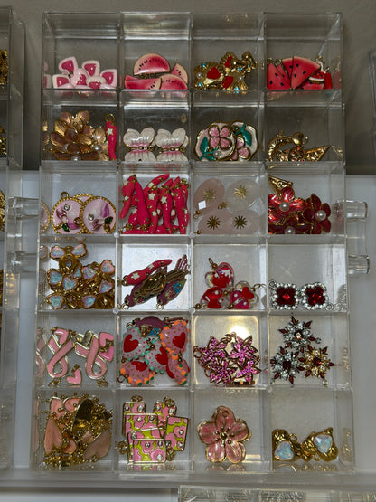 Tray of pink and red bow and heart charms