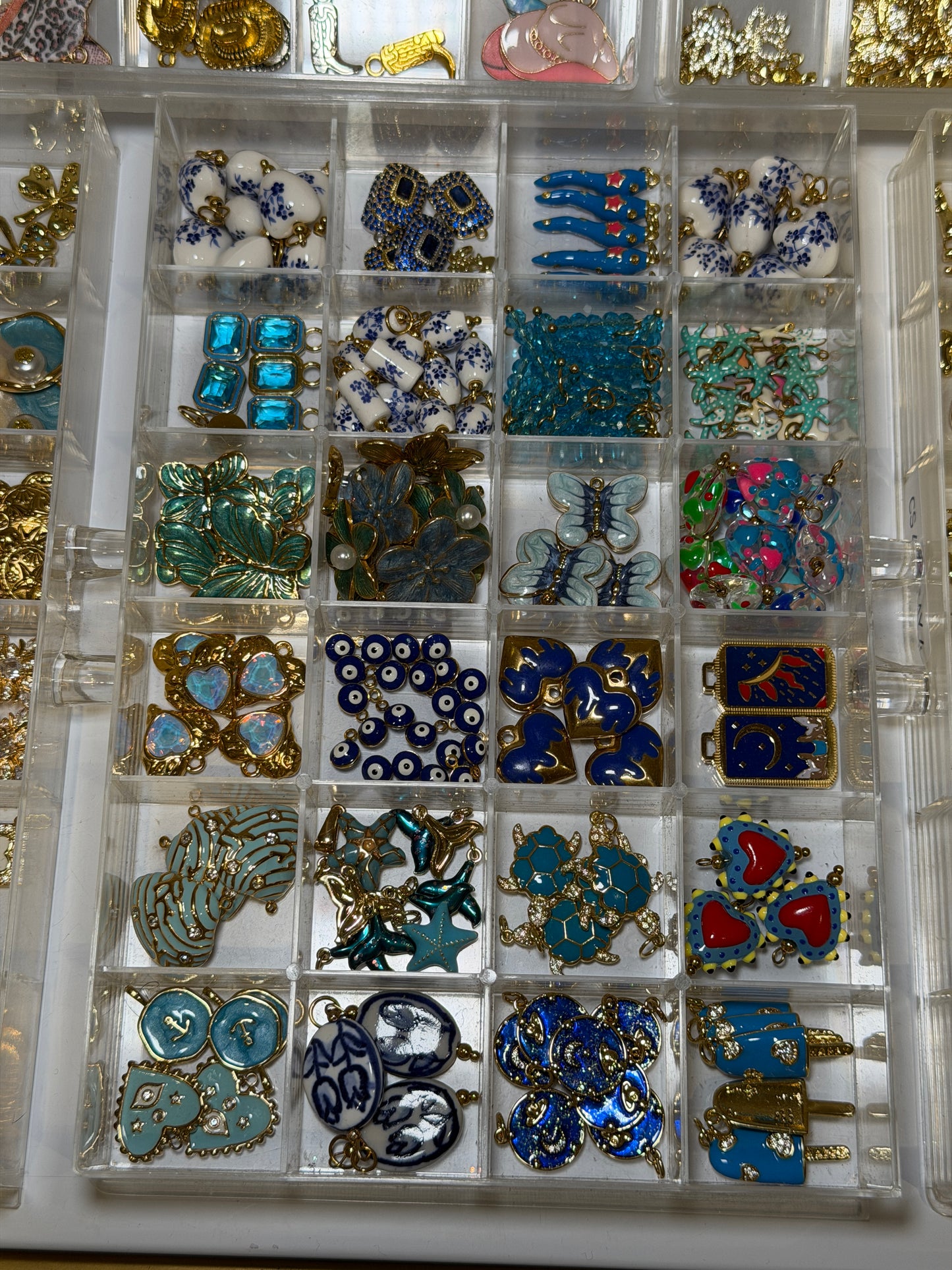 Tray of blue and turquoise charms including evil eye and gemstone pieces