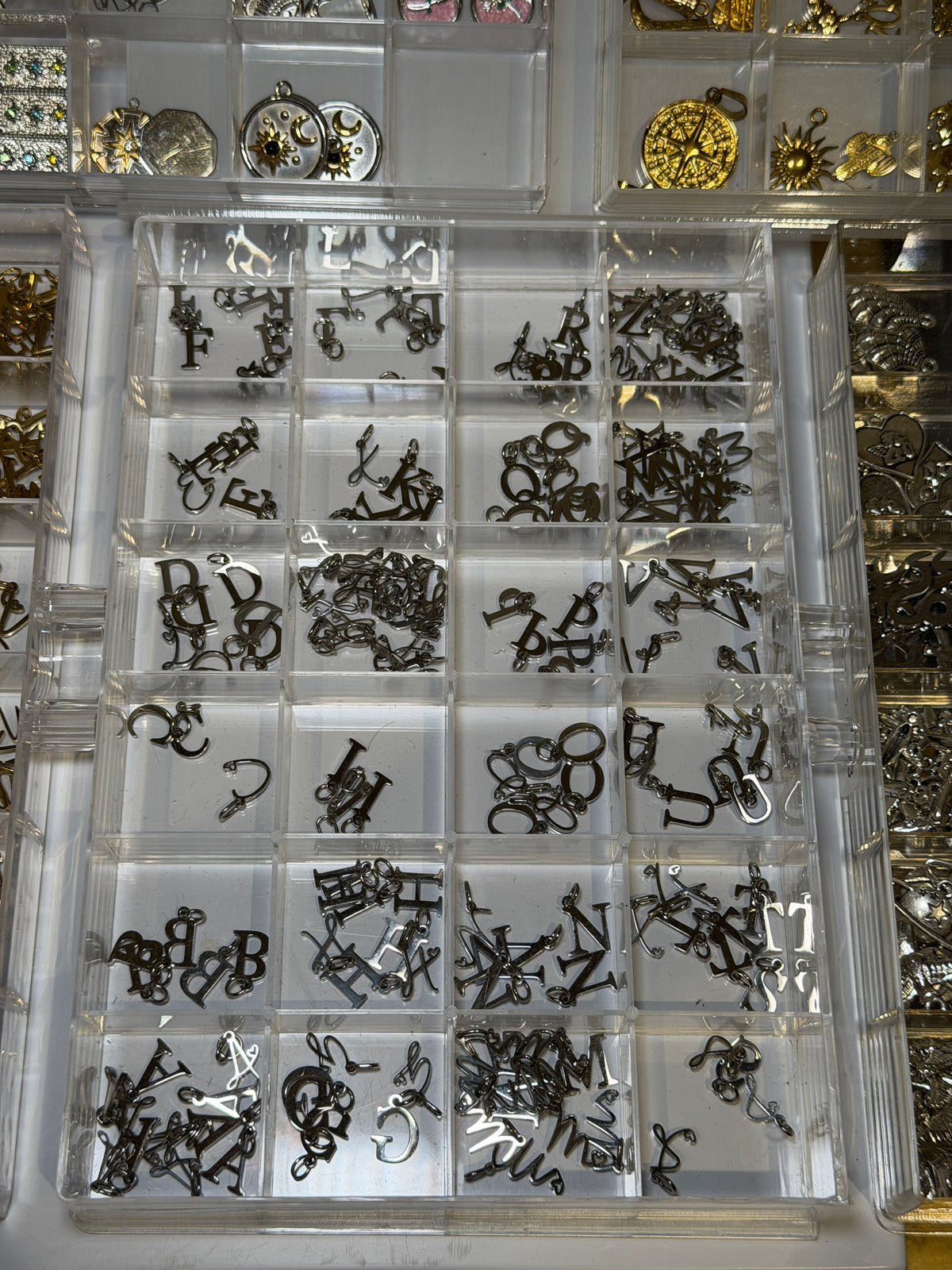 Tray of silver plated charms in assorted shapes