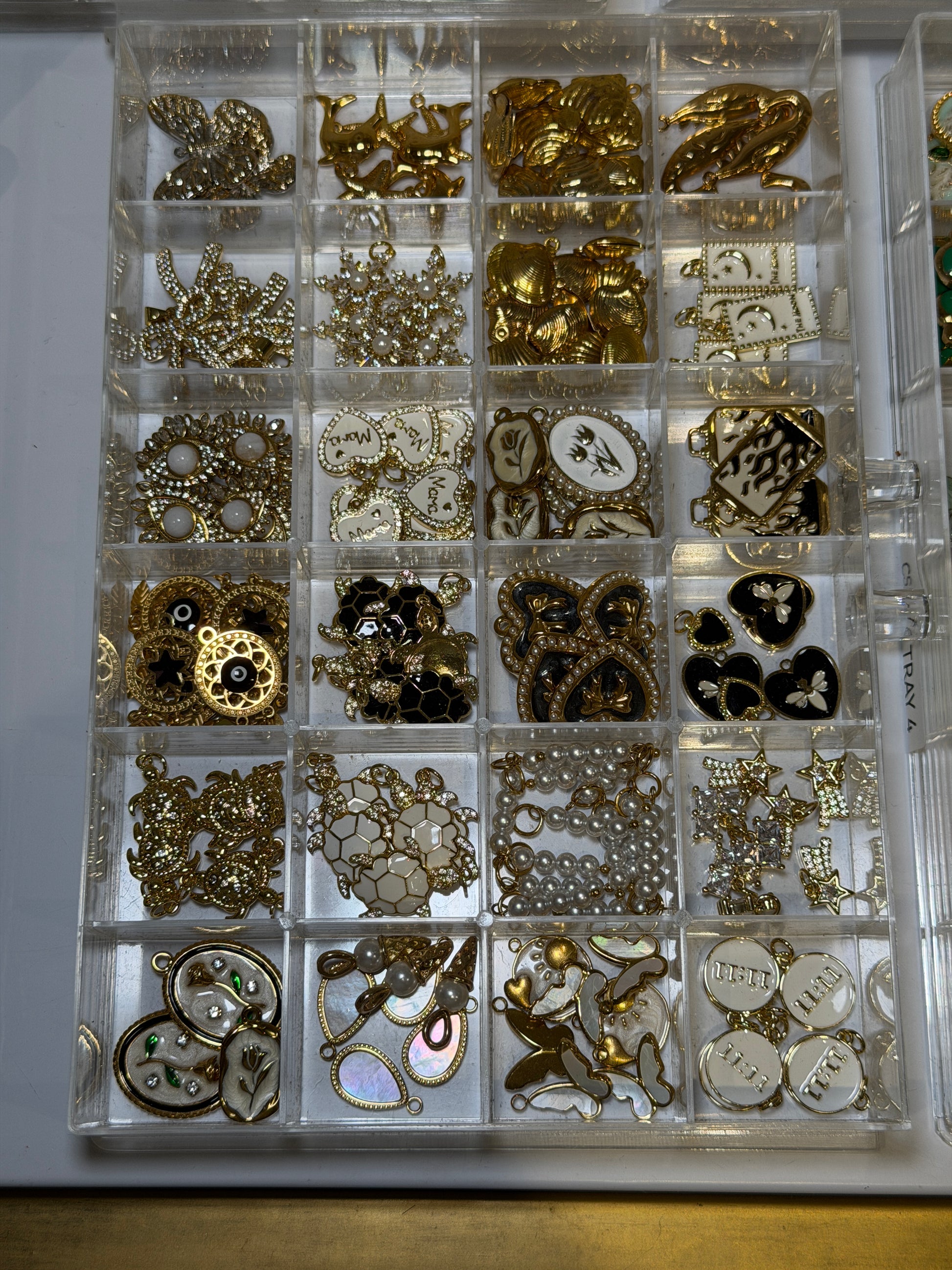 Compartment tray of gold plated charms to choose from