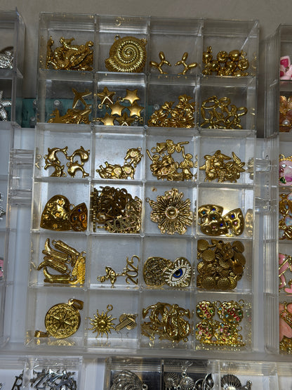 Tray of gold flower and spiral charms