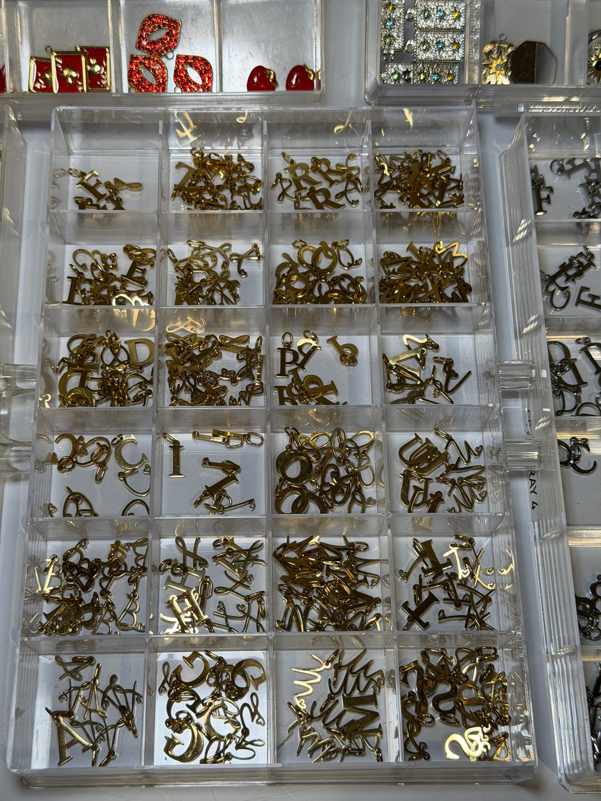 Tray of gold alphabet charms laid out by letter