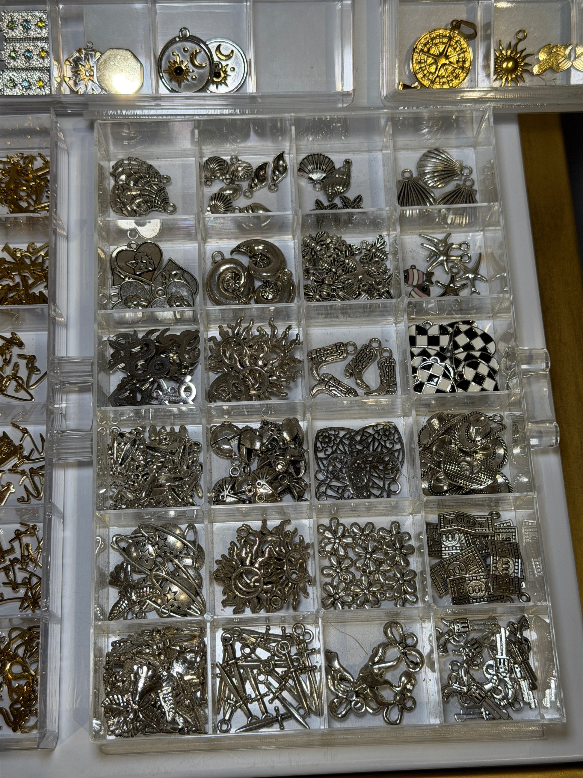 Tray of silver charms including chequered and patterned designs