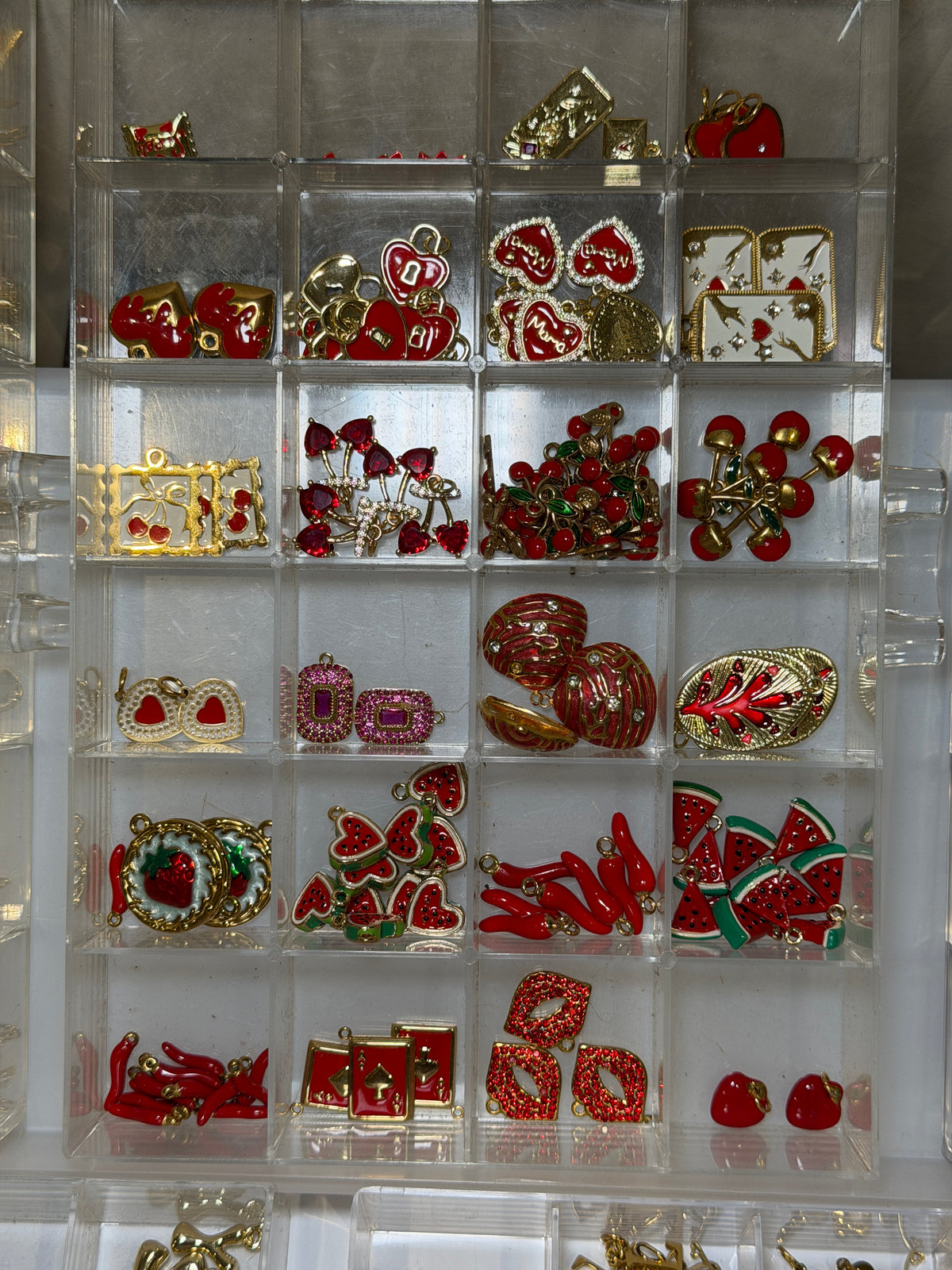 Tray of red and gold charms including bows, hearts and festive pieces