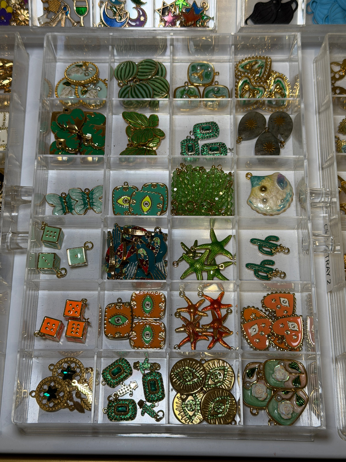 Tray of green and gold charms including turtles, leaves and star shapes