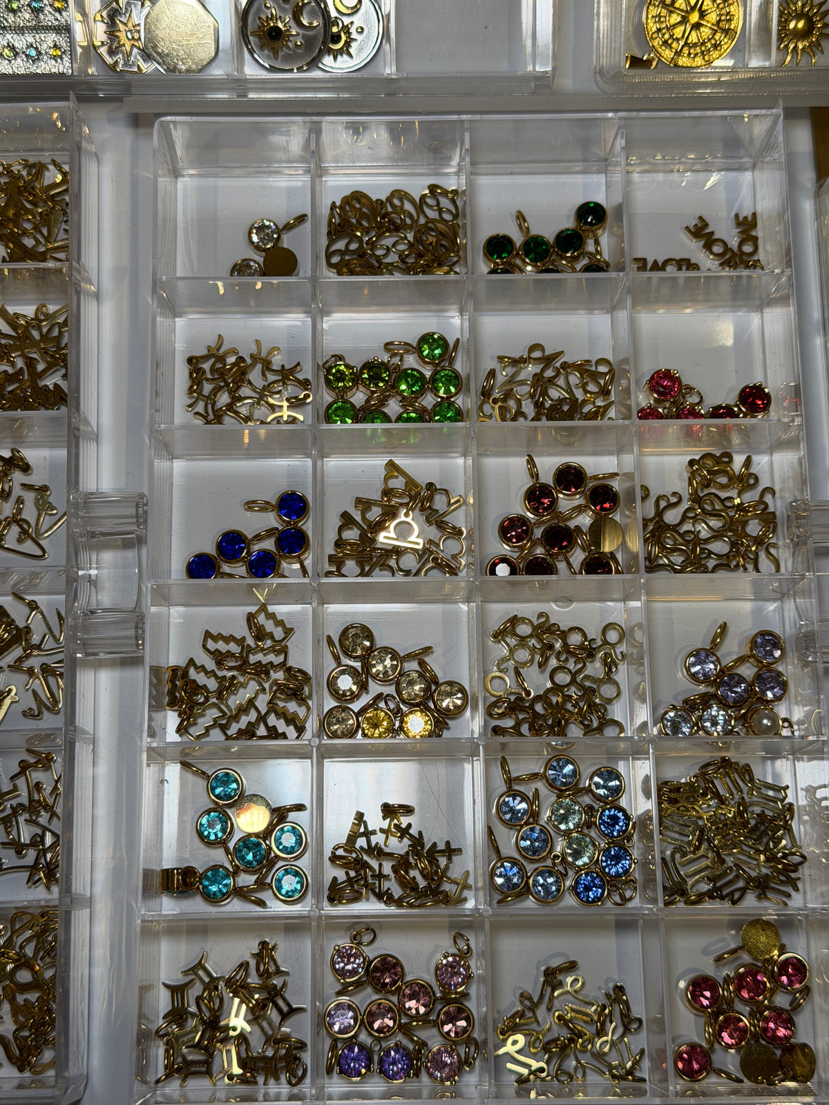 Tray of gold charms set with coloured gemstones
