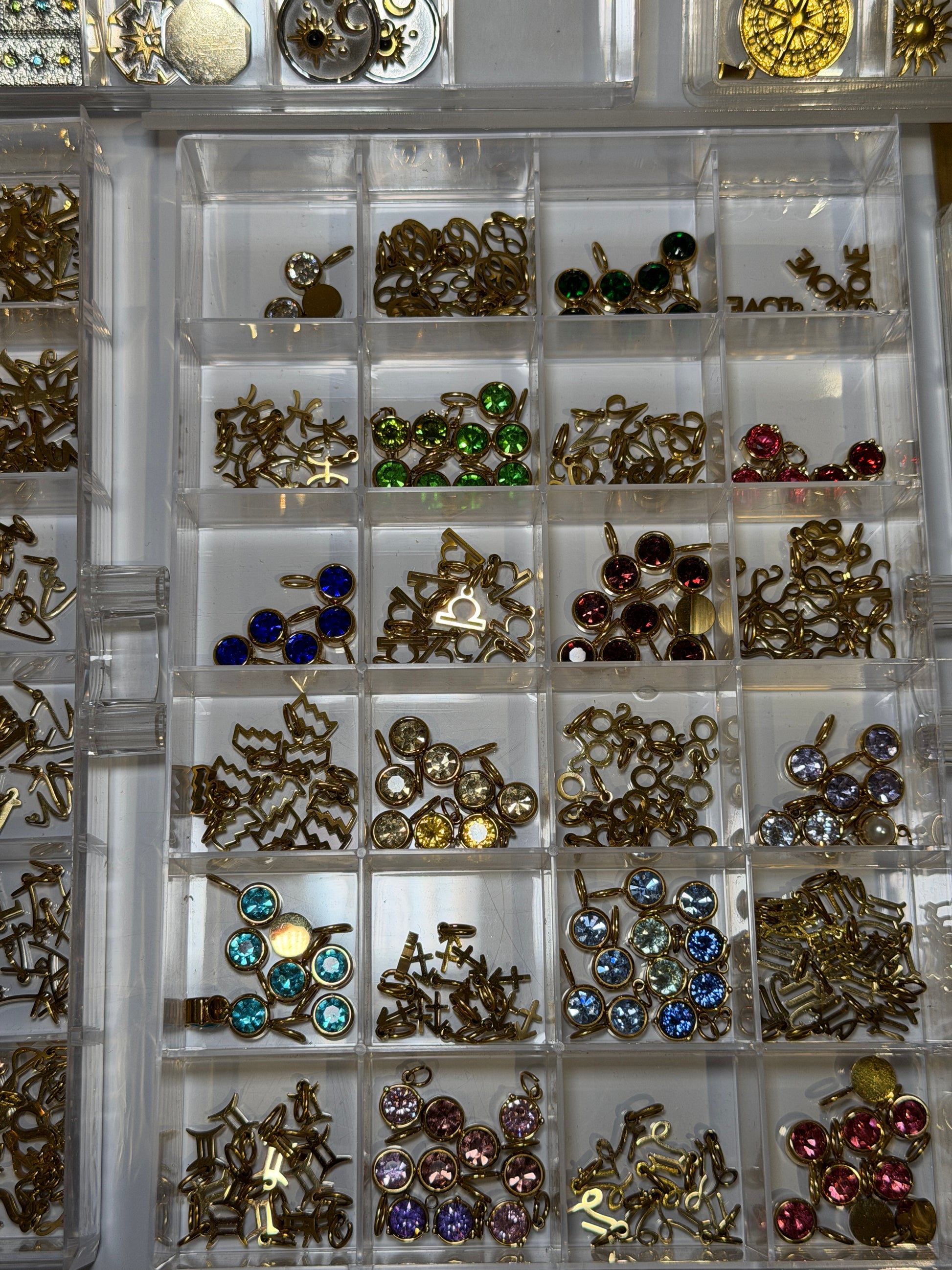 Tray of gold charms set with coloured gemstones