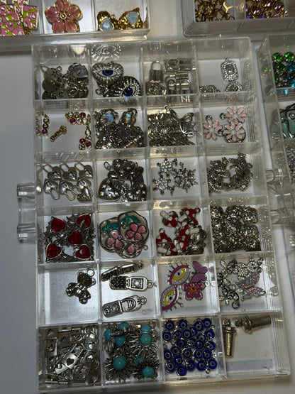 Tray of mixed charms set with red and clear stones
