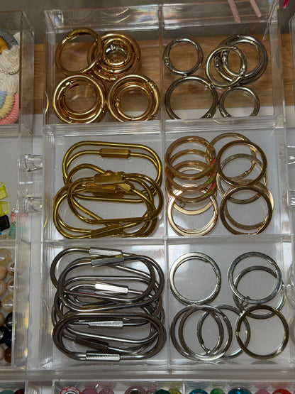 Tray of gold carabiners and split rings, the bases every bag charm is built on