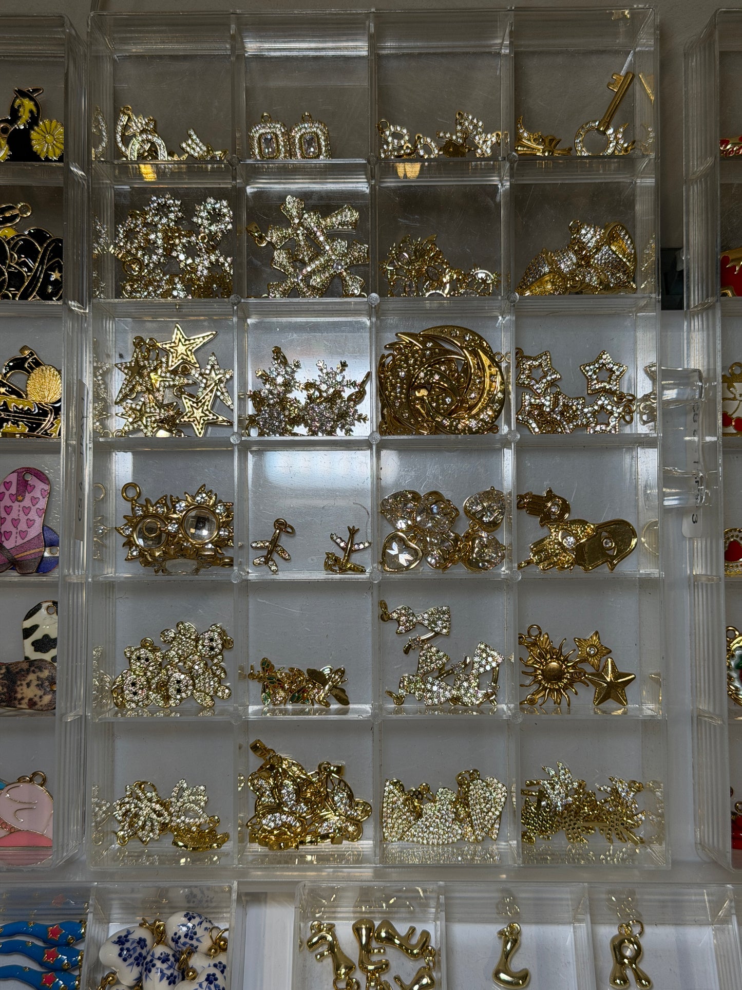 Tray of small gold charms including keys, hearts and geometric shapes