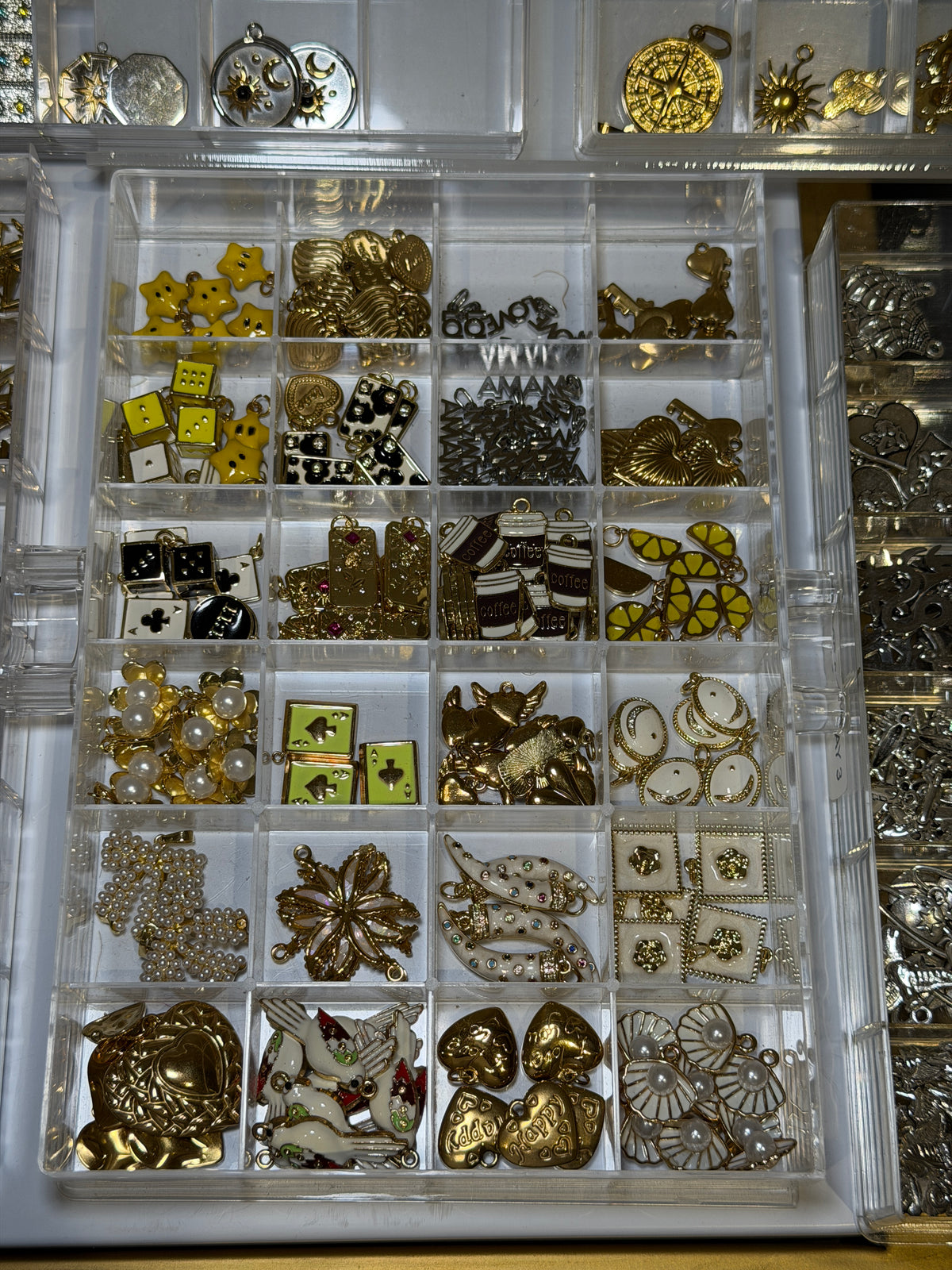 Tray of gold charms including yellow stones and flower designs