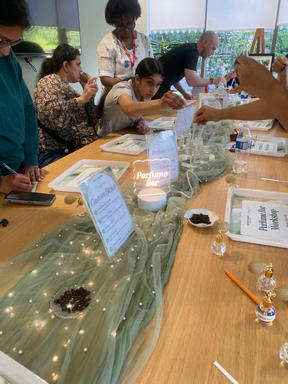 A group Perfume Bar workshop by Breaking Hearts Jewels, colleagues blending their own perfume around a long table