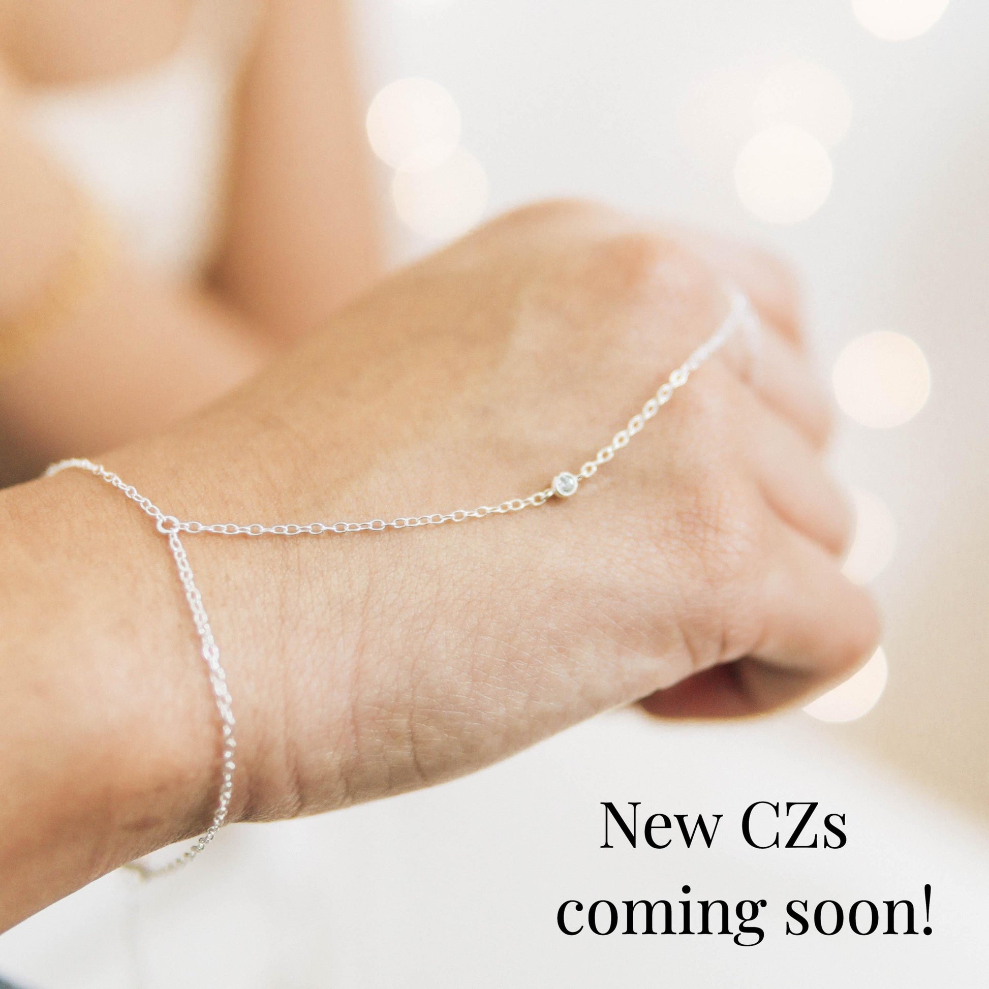 a woman's arm with a chain bracelet on it