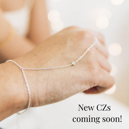 a woman's arm with a chain bracelet on it