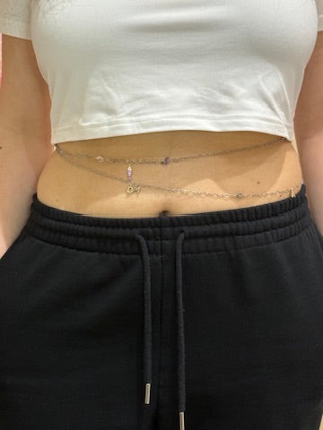 A silver permanent belly chain with small beaded detail