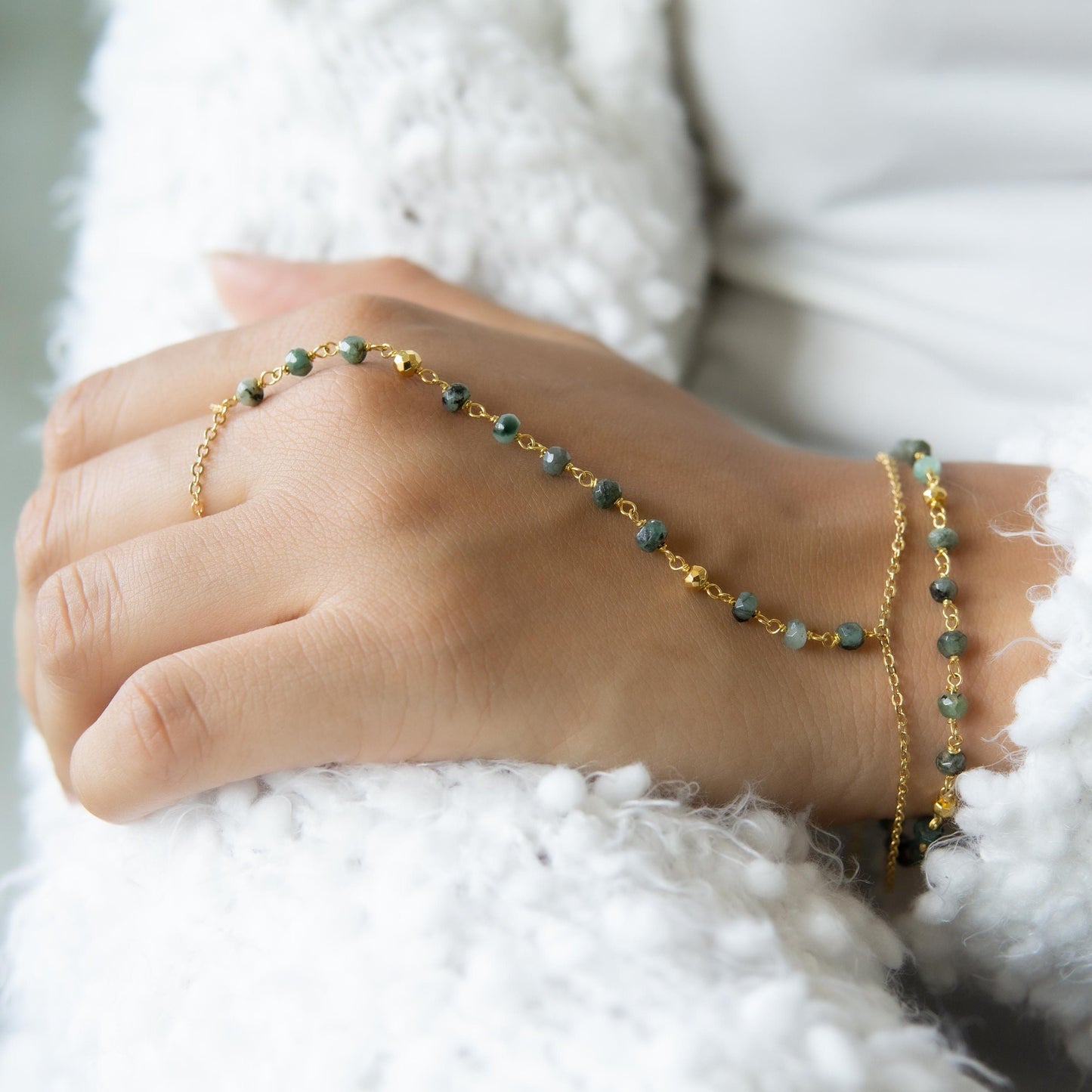 a woman's hand holding a beaded bracelet Traveler's gemstone finger bracelet Waterproof birthstone hand chain